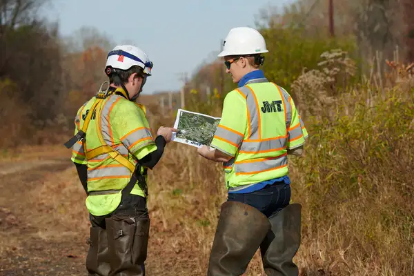 Two employees in PPE looking at plans on site