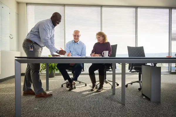 Three employees looking at plans on table